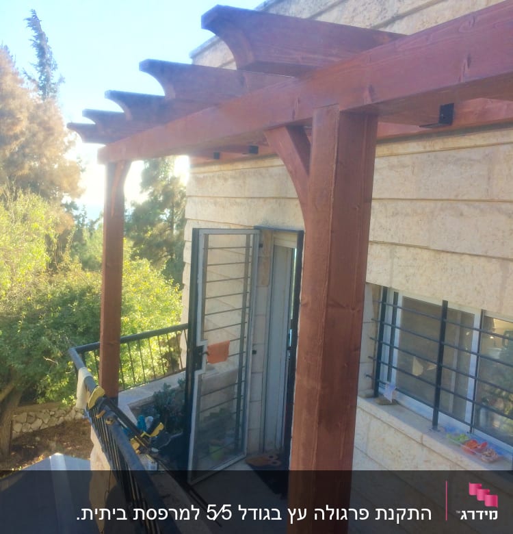 פרגולה מעץ על מרפסת עם דלת פתוחה
